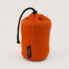 Load image into Gallery viewer, APEX 450ml titanium mug in orange mesh drawstring pouch with a black cord, shown on a light gray background.
