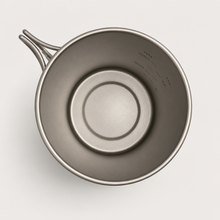 Load image into Gallery viewer, Top-down view of an APEX titanium camping 750ml mug with a foldable handle and printed measurement markings inside the rim, shown on a light gray background.