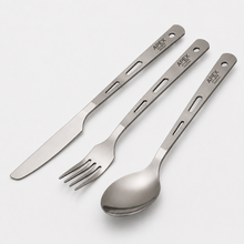 Load image into Gallery viewer, 3-piece titanium cutlery flatware set with engraved handles, including a knife, fork, and spoon, branded APEX. The utensils are arranged diagonally on a light gray background.
